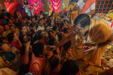Howrah, Batı Bengal, Hindistan - 4 Ekim 2022: Hindu Purohit çizimi tilok, bahşiş - Durga puja 'da erkek müridin alnında hayırlı bir nokta, unesco soyut kültürel miras.