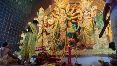 Howrah, Batı Bengal, Hindistan - 5 Ekim 2022: Hindu Rahip 'in tanrıça Durga' ya tapması, sinek çırpma fanı. Gece Ashtami puja aarati. Durga puja soyut, soyut bir kültür mirası..
