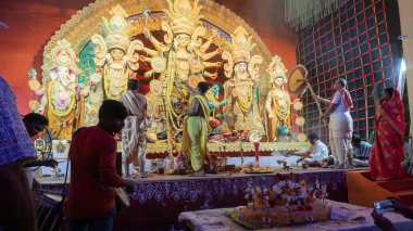 Howrah, Batı Bengal, Hindistan - 5 Ekim 2022: Dhaakis, Durga puja pandalının içinde kutsal dumanla kaplanmış dhaaks oynarken Tanrıça Durga 'ya kutsal tatlı Vog sunan Hindu Purohits.