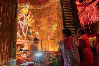 Howrah, Batı Bengal, Hindistan - 3 Ekim 2022: Hindu Purohit Durga 'ya Durga Puja pandalının içinde puja malzemeleriyle tapıyor. Durga Puja ayini. Hinduizm 'in en büyük festivali.