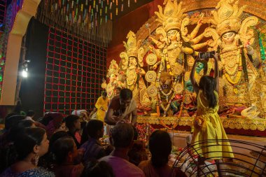 Howrah, Batı Bengal, Hindistan - 4 Ekim 2022: Hindu Purohit çizimi tilok, bahşiş - Durga puja 'da kadın müridin alnında uğurlu bir nokta, unesco soyut kültürel miras.