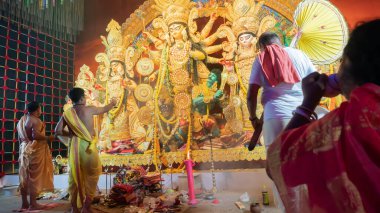 Howrah, Batı Bengal, Hindistan - 5 Ekim 2022: İlahi Şahin naad, Tanrıça Durga 'ya taparken Hindu dindar kadın deniz kabuğu üflüyor. Durga Puja ayini. Hinduizm 'in en büyük festivali.