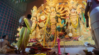 Howrah, Batı Bengal, Hindistan - 5 Ekim 2022: Hindu Rahip 'in tanrıça Durga' ya tapması, sinek çırpma fanı. Gece Ashtami puja aarati. Durga puja soyut, soyut bir kültür mirası..