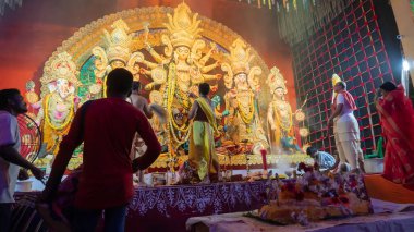 Howrah, Batı Bengal, Hindistan - 5 Ekim 2022: Dhaakis, Durga puja pandalının içinde kutsal dumanla kaplanmış dhaaks oynarken Tanrıça Durga 'ya kutsal tatlı Vog sunan Hindu Purohits.