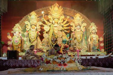 Howrah, Batı Bengal, Hindistan - 5 Ekim 2022: Vog, Tanrıça Durga 'ya verilen kutsal yemek, arka planda puja aranması. Durga Puja ritüeli. Hinduizm' in en büyük festivali..