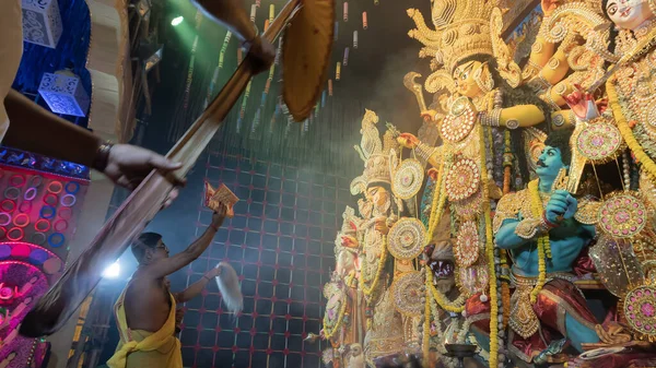 Howrah, Batı Bengal, Hindistan - 5 Ekim 2022: Hindu Purohit, Durga Puja pandalının içinde, geleneksel Hindu kadın elbisesi olan Sari ile tanrıça Durga 'ya tapıyor. Durga Puja ritüeli.