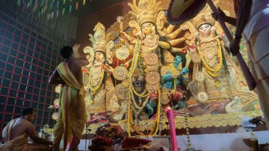 Howrah, Batı Bengal, Hindistan - 5 Ekim 2022: Hindu Rahip 'in tanrıça Durga' ya tapması, sinek çırpma fanı. Gece Ashtami puja aarati. Durga puja soyut, soyut bir kültür mirası..