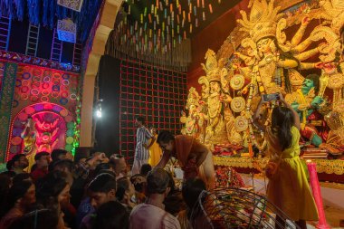 Howrah, Batı Bengal, Hindistan - 4 Ekim 2022: Hindu Purohit çizimi tilok, bahşiş - Durga puja 'da kadın müridin alnında uğurlu bir nokta, unesco soyut kültürel miras.