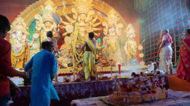 Howrah, Batı Bengal, Hindistan - 5 Ekim 2022: Dhaakis Tanrıça Durga 'ya tapmak için dhaaks çalarken, Tanrıça' ya Vog, kutsal tatlı yiyecekler sunuluyor. Puja pandalında kutsal bir Durga Puja ritüeli..