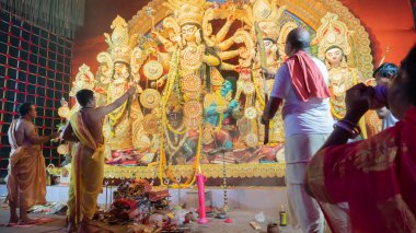 Howrah, Batı Bengal, Hindistan - 5 Ekim 2022: İlahi Şahin naad, Tanrıça Durga 'ya taparken Hindu dindar kadın deniz kabuğu üflüyor. Durga Puja ayini. Hinduizm 'in en büyük festivali.