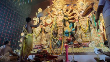 Howrah, Batı Bengal, Hindistan - 5 Ekim 2022: Hindu Rahip 'in tanrıça Durga' ya tapması, sinek çırpma fanı. Gece Ashtami puja aarati. Durga puja soyut, soyut bir kültür mirası..