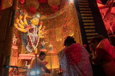Howrah, Batı Bengal, Hindistan - 3 Ekim 2022: Hindu Purohit Durga 'ya Durga Puja pandalının içinde puja malzemeleriyle tapıyor. Durga Puja ayini. Hinduizm 'in en büyük festivali.