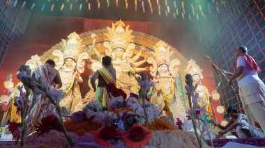 Howrah, Batı Bengal, Hindistan - 5 Ekim 2022: Hindu Purohits Tanrıça Durga için kutsal tatlı yiyecekler sunarken Durga puja pandalının içinde kutsal dumanla kaplı.