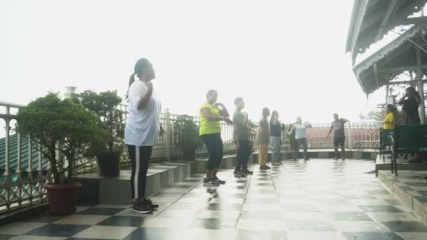 大吉岭 西孟加拉邦 2023 4K有健康意识的年轻女性在大吉岭购物中心的雾蒙蒙的早晨进行集体锻炼的视频 年轻的喜马拉雅人的生活方式 有节奏地穿着运动服跳舞 — 图库视频影像