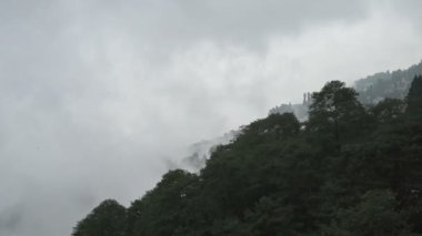 Hindistan, Batı Bengal, Darjeeling 'deki Himalaya dağlarının üzerinden geçen muson bulutlarının yavaş çekim videosu. Darjeeling, tepelerin kraliçesi ve yağmurlu mevsimde güzel yeşil tepeleri olan çok manzaralı bir yerdir..