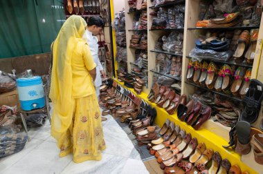 Jodhpur, Rajasthan, Hindistan - 15.10.2019: Rajasthani erkek ve kadın ayakkabıları satışa sunuldu. Jaisalmer, Rajasthan, Hindistan. Rajasthani erkek ve kadın ayakkabı almaya çalışıyorlar..