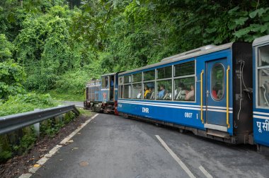Darjeeling, Batı Bengal, Hindistan - 10 Ağustos 2023: Himalaya yol ve ormanlarından geçen Diesel Oyuncak treni. Darjeeling Himalaya Demiryolu, Yeni Jalpaiguri ve Darjeeling arasındaki dar ölçü demiryolu.