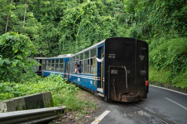 Darjeeling, Batı Bengal, Hindistan - 10 Ağustos 2023: Himalaya yol ve ormanlarından geçen Diesel Oyuncak treni. Darjeeling Himalaya Demiryolu, Yeni Jalpaiguri ve Darjeeling arasındaki dar ölçü demiryolu.