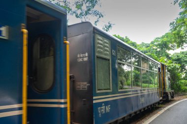 Darjeeling, Batı Bengal, Hindistan - 10 Ağustos 2023: Himalaya yol ve ormanlarından geçen Diesel Oyuncak treni. Darjeeling Himalaya Demiryolu, Yeni Jalpaiguri ve Darjeeling arasındaki dar ölçü demiryolu.