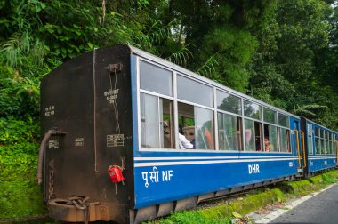Darjeeling, Batı Bengal, Hindistan - 10 Ağustos 2023: Himalaya yol ve ormanlarından geçen Diesel Oyuncak treni. Darjeeling Himalaya Demiryolu, Yeni Jalpaiguri ve Darjeeling arasındaki dar ölçü demiryolu.