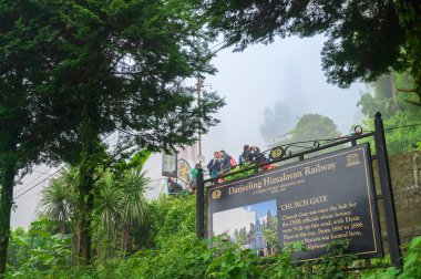 Kurseong, Batı Bengal, Hindistan - 10 Ağustos 2023: Eski Kurseong tren istasyonu, Himalaya dağları ve yemyeşil ormanlarla ilgili tarihi detayları içeren Kilise Kapısı levhası. Manzaralı doğal güzellik.