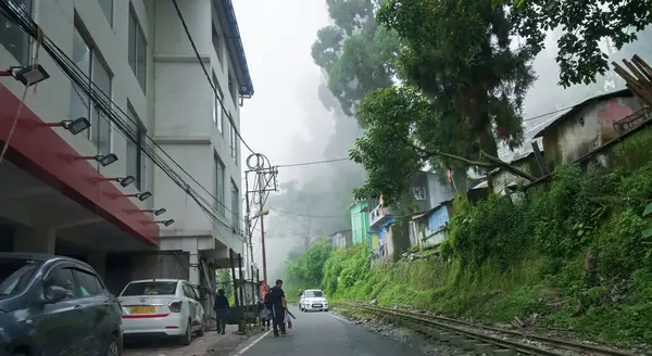 Stock image Kurseong, West Bengal,India - 10th August 2023 : Homes and a concrete road passing through Himalayan mountains and lush green forest. Scenic natural beauty of monsoon in Kurseong, Darjeeling district.