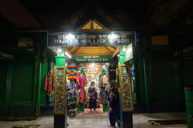 Darjeeling, West Bengal, India - 10.08.2023 : Night time view of Darjeeling Mall. Famous shop of Habeeb Mullick & Son, famous for selling various items including clothes, sweater, gift items etc. clipart