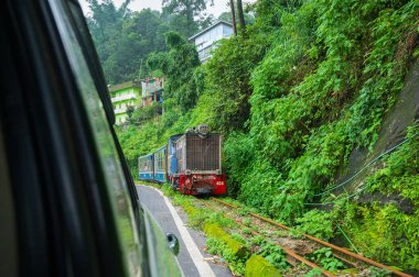 Darjeeling, Batı Bengal, Hindistan - 10 Ağustos 2023: Himalaya yol ve ormanlarından geçen Diesel Oyuncak treni. Darjeeling Himalaya Demiryolu, Yeni Jalpaiguri ve Darjeeling arasındaki dar ölçü demiryolu.