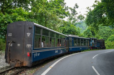 Darjeeling, Batı Bengal, Hindistan - 10 Ağustos 2023: Himalaya yol ve ormanlarından geçen Diesel Oyuncak treni. Darjeeling Himalaya Demiryolu, Yeni Jalpaiguri ve Darjeeling arasındaki dar ölçü demiryolu.