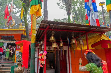 Darjeeling, Batı Bengal, Hindistan-11.08.2023: Hindu genç kadın çan çalıyor. Mahakal Tapınağı, Hindu tapınağı Shiva için ve Hindu ve Budist dinlerin barış içinde bir arada var olmalarının birleşimidir..