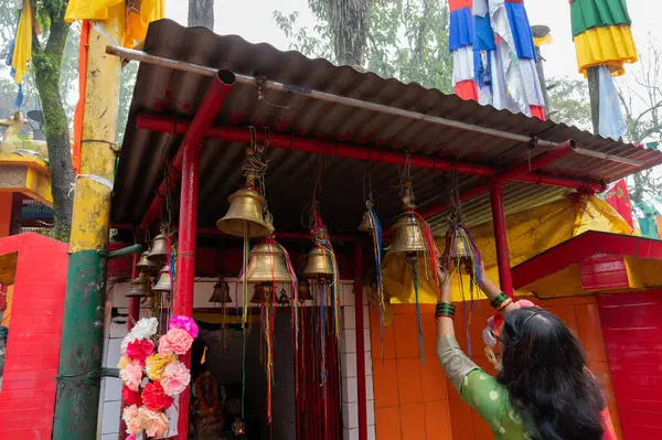 Stock image Darjeeling,West Bengal,India-11.08.2023: Hindu young woman devotee ringing bell. Mahakal Temple,Hindu temple for God Shiva and is an amalgamation of Hindu and Buddhist religions coexisting peacefully.