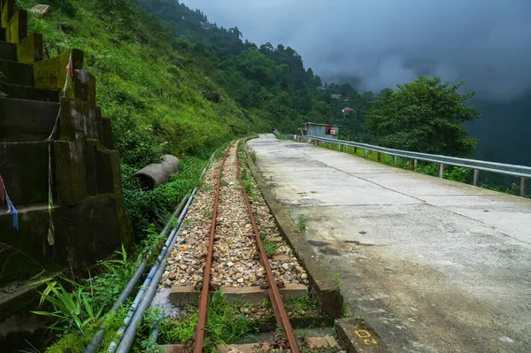 Stock image Concrete road passing through Himalayan mountains and lush green forest. Scenic natural beauty of monsoon in Darjeeling, West Bengal, India.