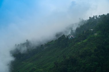 Hindistan, Batı Bengal, Darjeeling 'deki Himalaya dağlarının üzerinden geçen muson bulutları. Darjeeling, tepelerin kraliçesi ve yağmurlu mevsimde güzel yeşil tepeleri olan çok manzaralı bir yerdir..