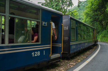 Darjeeling, Batı Bengal, Hindistan - 10 Ağustos 2023: Himalaya yol ve ormanlarından geçen Diesel Oyuncak treni. Darjeeling Himalaya Demiryolu, Yeni Jalpaiguri ve Darjeeling arasındaki dar ölçü demiryolu.