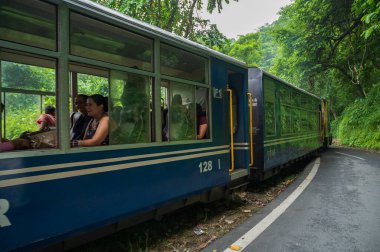 Darjeeling, Batı Bengal, Hindistan - 10 Ağustos 2023: Himalaya yol ve ormanlarından geçen Diesel Oyuncak treni. Darjeeling Himalaya Demiryolu, Yeni Jalpaiguri ve Darjeeling arasındaki dar ölçü demiryolu.