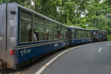 Darjeeling, Batı Bengal, Hindistan - 10 Ağustos 2023: Himalaya yol ve ormanlarından geçen Diesel Oyuncak treni. Darjeeling Himalaya Demiryolu, Yeni Jalpaiguri ve Darjeeling arasındaki dar ölçü demiryolu.