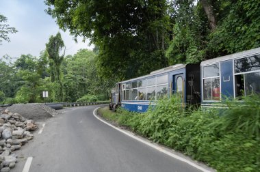 Darjeeling, Batı Bengal, Hindistan - 10 Ağustos 2023: Himalaya yol ve ormanlarından geçen Diesel Oyuncak treni. Darjeeling Himalaya Demiryolu, Yeni Jalpaiguri ve Darjeeling arasındaki dar ölçü demiryolu.