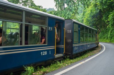 Darjeeling, Batı Bengal, Hindistan - 10 Ağustos 2023: Himalaya yol ve ormanlarından geçen Diesel Oyuncak treni. Darjeeling Himalaya Demiryolu, Yeni Jalpaiguri ve Darjeeling arasındaki dar ölçü demiryolu.