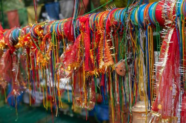 Hindu religious threads with wishes of devotees and Buddhist religious flags in background at Mahakal Temple, an amalgamation of Hindu and Buddhist religions coexisting. Darjeeling,West Bengal,India. clipart