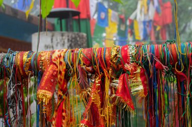 Hindu dini ilmikleri ve Mahakal Tapınağı 'nın arka planında Hindu dindarların ve Budist dinlerin birleşimi olan Budist dini bayrakları vardır. Darjeeling, Batı Bengal, Hindistan.