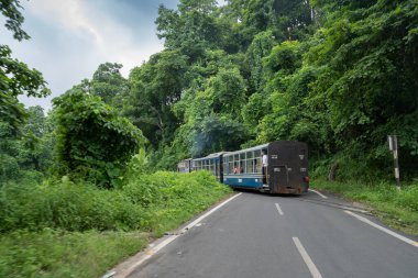 Darjeeling,West Bengal,India - 10th August 2023 : Diesel Toy train passing through Himalayan roads and jungle. Darjeeling Himalayan Railway, narrow gauge railway between New Jalpaiguri and Darjeeling. clipart