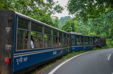Darjeeling, Batı Bengal, Hindistan - 10 Ağustos 2023: Himalaya yol ve ormanlarından geçen Diesel Oyuncak treni. Darjeeling Himalaya Demiryolu, Yeni Jalpaiguri ve Darjeeling arasındaki dar ölçü demiryolu.