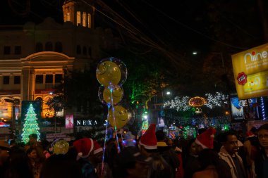 Kolkata, West Bengal, India - 25.12.2018 : Decorated balloons, lights and Christmas celebration at illuminated Park street with joy and year end festive mood. Dark sky background. clipart