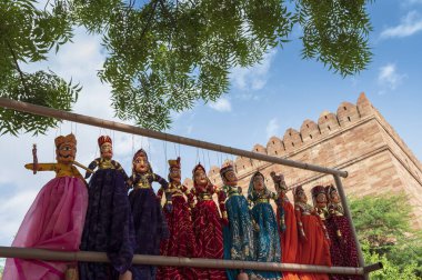 Traditional King and queen, called Raja Rani, handmade puppets or Katputli Sets are hanging for sale inside Meharangarh fort, Jodhpur, Rajasthan, India. Dolls in Jodhpur popular and sold to tourists.