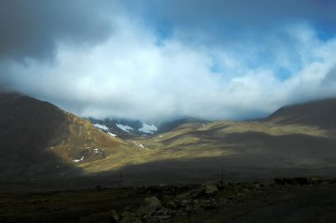 Hindistan, Sikkim 'deki Gurudongmar Gölü' ne giden yolun yanındaki Himalaya dağlarında ışık ve gölge oyunu. Budistler, Sihler ve Hindular tarafından kutsal kabul edilir. Adını Guru Padmasambhava 'dan alan Guru Rinpoche.