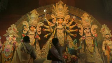 Howrah, Batı Bengal, Hindistan - 3 Ekim 2022: Hindu rahipler beyaz deniz kabuğu kabuğuyla tanrıça Durga 'ya tapıyorlar. Ashtami puja aarati - kutsal Durga Puja ritüeli - Hinduizm fetivali, gece.