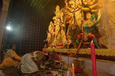 Howrah, Batı Bengal, Hindistan- 3 Ekim 2022: Hindu Rahip saygı göstererek, dua ederek ve tanrıça Durga 'ya taparak diz çöker. Puja Pandalı. Durga puja soyut, soyut bir kültür mirası..