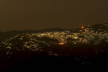 Pearls of light of Queen of Hills, Darjeeling town, at night. In the Eastern Himalayas, To the west of Darjeeling lies Nepal, to the east the Kingdom of Bhutan, to the north Sikkim.West Bengal, India. clipart