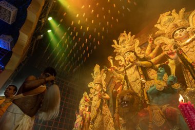Howrah, Batı Bengal, Hindistan - 3 Ekim 2022: Hindu Rahip 'in tanrıça Durga' ya tapması, sinek çırpma fanı. Gece Ashtami puja aarati. Durga puja soyut, soyut bir kültür mirası..