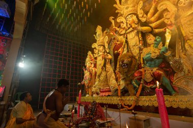 Howrah, Batı Bengal, Hindistan - 3 Ekim 2022: Hindu rahipler ellerini katlayarak tanrıça Durga 'ya dua ediyor ve ona tapıyorlar.Puja Pandal.Durga puja soyut, soyut bir kültür mirası..